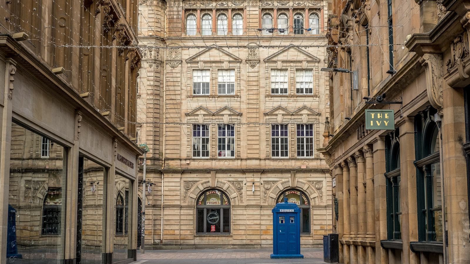 Sandstone buildings on Royal Exchange Court in Glasgow city centre, with a blue police box in the foreground